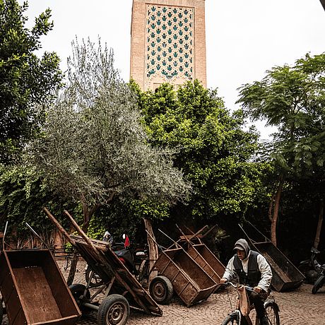 Private Fototour Marrakesch Galerie Fahrradfahrer und Gepäckkarren vor Minarett