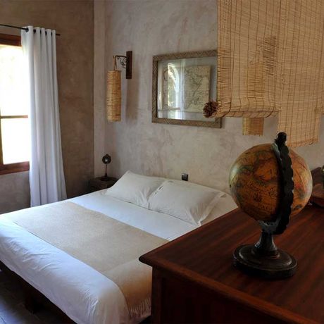 Blick auf ein Bett und eine Kommode im Schlafbereich der Suite Voyages