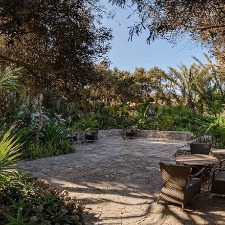 Blick auf Sitzmoeglichkeiten auf einer Terrasse im Garten des Riads Villa Blanche