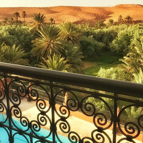 Blick von einem Balkon ueber Palmen vor dem Riad Dar Bab Todra
