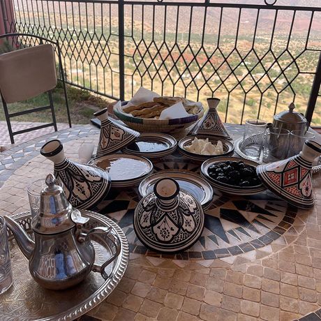 Blick auf einen gedeckten Esstisch mit Speisen und Tee auf der Terrasse der Auberge Zolado