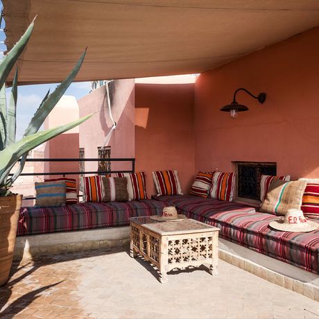 Blick auf ein großes Sofa an einem Couchtisch auf der Terrasse einer Familiensuite mit 2 Schlafzimmern