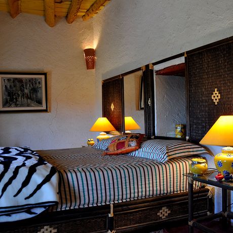 Blick auf ein Bett mit zwei Nachttischen im Schlafbereich des Superiorzimmers Fatima