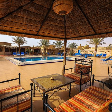 Blick auf einen Sitzbereich am Pool des Kasbah-Hotels Ksar Bicha