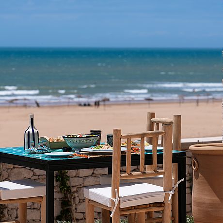 Mahzeit auf der Terrasse mit Blick auf Strand und Meer