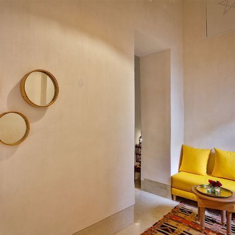 Blick auf ein Sofa und drei kleine Spiegel an einer Wand im Innenbereich des Riad Dar Baraka & Karam
