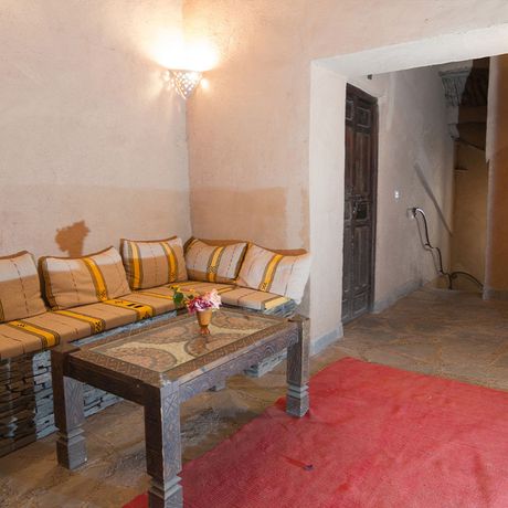 Blick auf eine Sitzbank mit einem Tisch im Innenbereich des Kasbah-Hotels Imdoukal