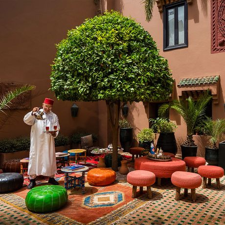 Eine Person schenkt den Tee im Innenhof ein im Kasbah-Hotel Tamadot