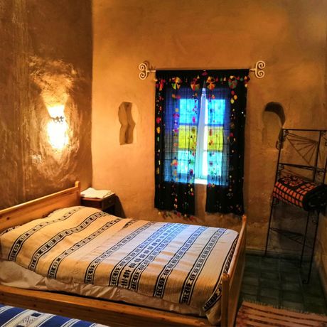 Blick auf ein Bett und einen Spiegel im Schlafbereich eines Standardzimmers mit Gemeinschaftsbad
