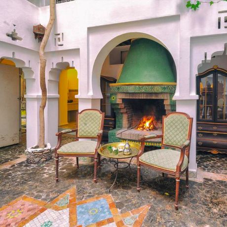 Blick auf eine Sitzecke vor einem Kamin im Innenbereich des Hotels Dar Baibou