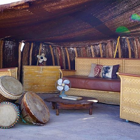 Blick auf einen SItzbereich mit Sofa und Sesseln in Aussenbereich des Wuestencamps Inara Camp