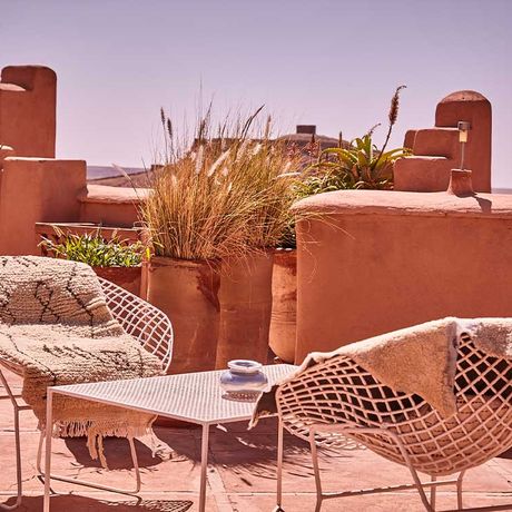Blick auf zwei Sessel an einem Tisch auf der Dachterrasse des Kasbah-Hotels Caravane