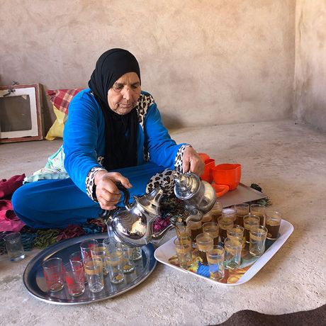 Frau giesst Tee in Glaeser ein