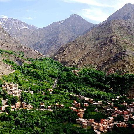 Blick auf ein Berberdorf in einem gruenen Tal