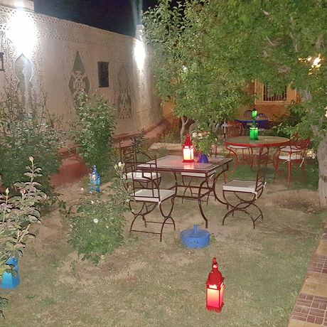 Blick auf Tische und Stuehle im Garten der Pension und Gaestehaus Riad Villa Midelt