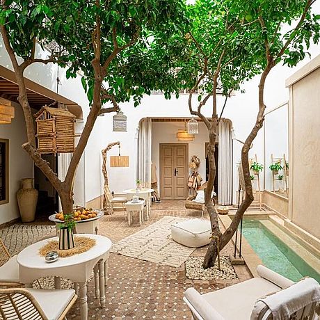 Riad Orangers d'Alilia Galerie Blick in den Innenhof mit Bäumen und Sitzgelegenheiten