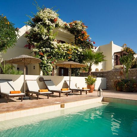Rebali Riads Galerie Pool mit Sonnenliegen und Bougainvilla-bewachsener Villa