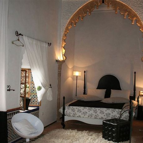 Blick auf ein Bett und einen Sessel im Schlafbereich des Superiorzimmers La Concubine