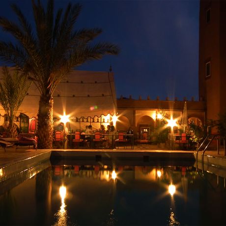 Blick auf den Poolbereich bei Nacht im Kasbah-Hotel Tomboctou