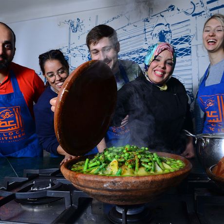 Blick auf eine Gruppe hinter einem frisch gekochten Gericht bei einem Kochkurs in Marokko
