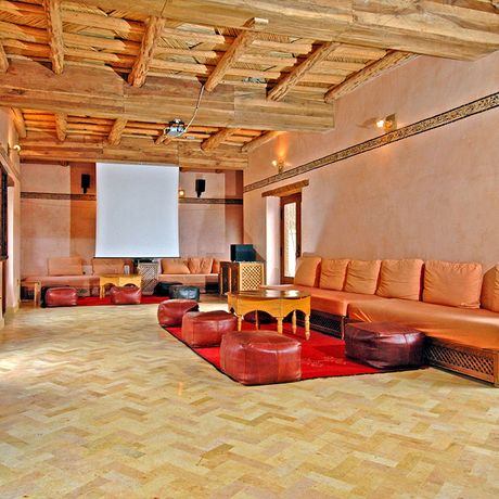 Blick auf Sitzmoeglichkeiten und eine Leinwand im Konferenzraum des Kasbah-Hotels du Toubkal