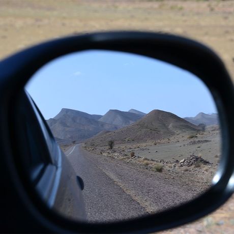 Blick auf Berge im Seitenspiegel eines Autos