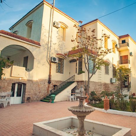 Blick auf die Pension und Gaestehaus Villa Pomme d´Or hinter einem Springbrunnen