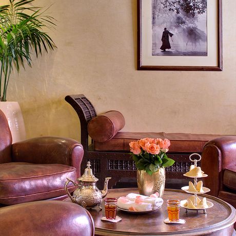 Blick auf drei Ledersessel an einem Tisch mit frischem Tee an der Rezeption des Boutique-Hotels les Jardins de la Medina