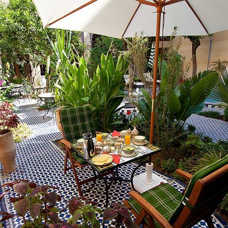 Blick auf einen gedeckten Fruehstueckstisch im Garten des Riad Salama