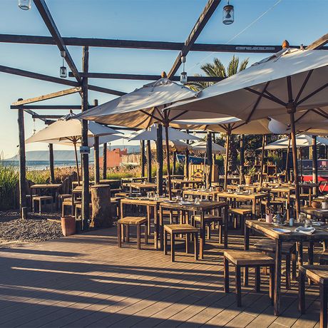 Blick auf gedeckte Tische im Restaurant am Strand des Hotels Paradis Plage