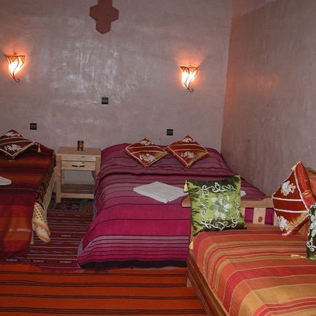 Blick auf zwei Betten und ein Sofa in einem Standardzimmer im Kasbah-Hotel Petit Nomade