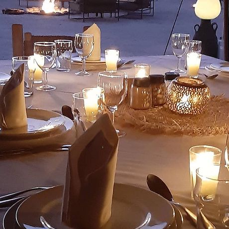 Blick auf einen gedeckten Tisch zum Abendessen im Wuestencamp Inara Camp
