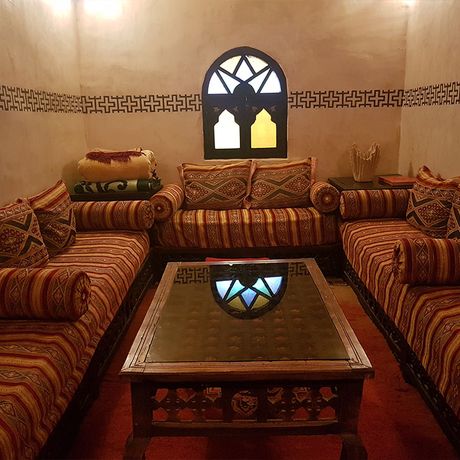 Blick auf Sofas und einen Tisch in einem Salon im Innenbereich des Kasbah-Hotels Rose du Sable