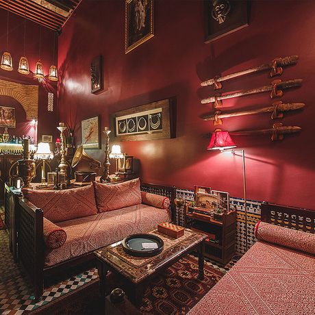 Blick auf zwei Sofas mit einem Tisch vor einer Bar im Salon des Riad le Calife