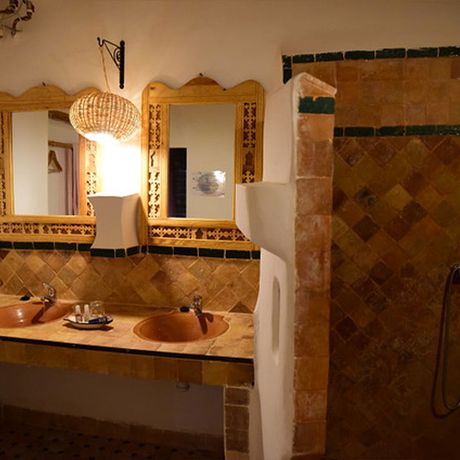 Blick auf zwei Waschbecken und eine Dusche im Badezimmer der Familiensuite Chezahra