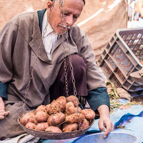 Mann verkauft Kartoffeln auf dem Berbermarkt Had Draa