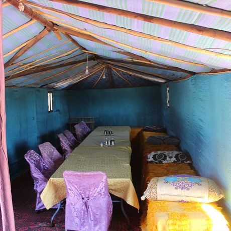 Blick auf Tische und Stuehle in einem Zelt im Wuestencamp Standard (Erg Chebbi)