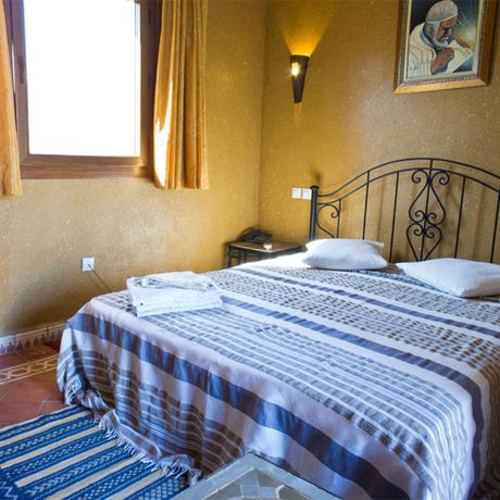 Blick auf ein Bett eines Standardzimmers im Hotel Kasbah Chez Amaliya in Tafraoute