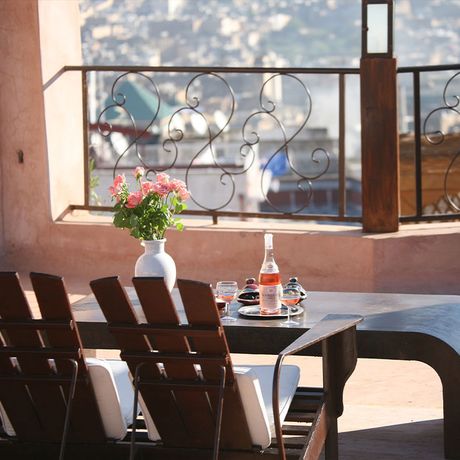 Blick auf eine Bank und einen Tisch auf der Terrasse im Riad Laaroussa