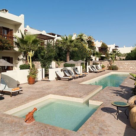 Rebali Riads Galerie Blick auf Pools mit Sitzgelegenheit und Sonnenliegen