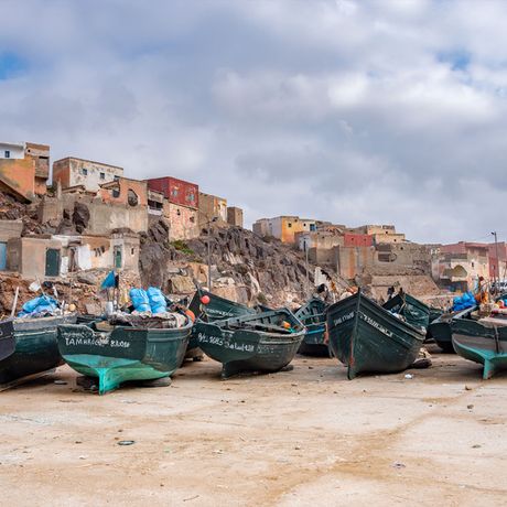 Blick auf Boote am Strand vor einem Dorf in Marokko