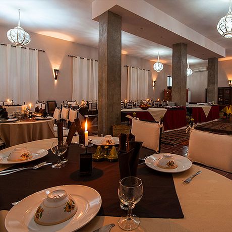Blick auf gedeckte Tische im Restaurant des Bungalows und Apartments Bab Rimal