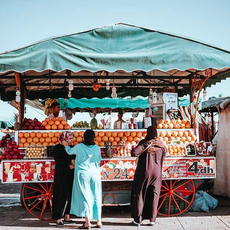 Blick auf Personen vor einem Obststand auf einem Souk in Marrakesch