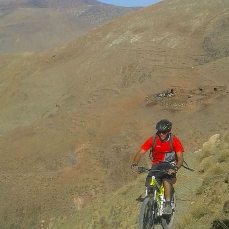 Blick auf einen Mountainbiker auf einem Weg an einem Berg in Marokko
