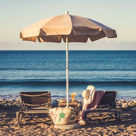 Blick auf zwei Liegen unter einem Sonnenschirm am Strand von Agadir
