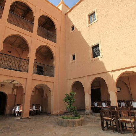 Blick auf Tische und Stuehle im Aussenbereich des Kasbah-Hotels Imdoukal